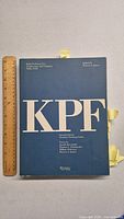 Front cover of the hardcover architecture book showing title 'KPF' and Rizzoli branding with a ruler for scale.