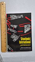 Front cover of the Situationist International Anthology book alongside a 12-inch ruler for scale.