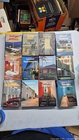 Eleven TeNeues architecture and design books arranged in a grid on a table, showing varied titles related to houses, hotels, apartments, office and restaurant design.