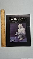 Front cover of The Storytellers book showing sculpture image and title