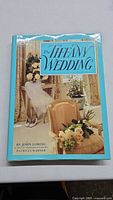 Front cover photo showing the title 'The Tiffany Wedding', with wedding decorations and floral arrangements in soft pastel colors.