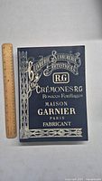 Front cover of vintage French reprint catalogue showing ornate decorative typography and design in gold or light color on dark background, featuring branding Maison Garnier Paris and R.G.
