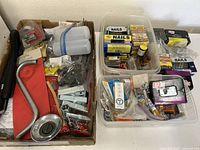 Three boxes/containers filled with assorted nails, fasteners, and hardware pieces, showing overall bulk of items