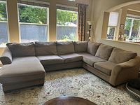 Full view of sectional sofa under windows