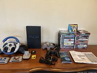 Full overview of console, controllers, memory card, cheat code book, manual, cables and stacked game cases