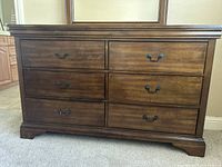 Front view of the dark brown dresser showing six drawers with metal pull handles.
