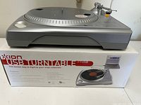 Side view of the ION iTTUSB USB turntable on top of its original box showcasing branding and features.