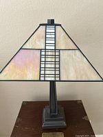 Front view of the stained glass shade showing geometric panel design and metal base.