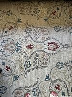 Close-up image showing the ivory polypropylene area rug with multicolored floral and leaf motifs, in good condition with minor wear.