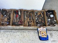 Full overview of all hand tools sorted across cardboard boxes arranged in a row showing wide variety of vintage tools.