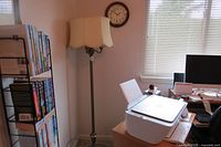 Floor lamp placed beside desk with printer and books, showing height and shade shape under ambient light.