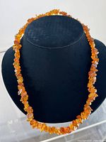 Full view of amber nugget necklace on display bust