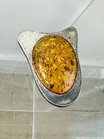 Front view showing amber cabochon in silver-tone setting