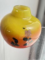 Overall view of round yellow-orange Murano glass vase