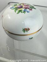 Lidded porcelain bowl side view showing floral design and gold band