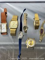 All seven watches laid out showing fronts and bracelets