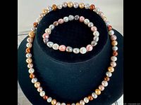 Necklace and bracelet displayed on stand, showing full strand lengths