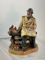 Front view of Royal Doulton Lunch Time figurine showing man, bench, squirrels
