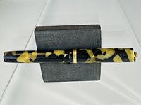 Full view of pen showing marbled celluloid and cap band
