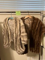 Both fur capelets hanging side by side on hangers