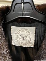 Close-up photo of inside label of darker brown fur jacket showing 'Hudson's Bay Company' logo and text