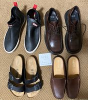 Top-down view of all four pairs of shoes and sandals arranged on carpet, showing different styles and logos.