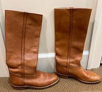 Pair of brown Frye leather mid-calf boots shown side by side upright, detailing leather texture and overall shape.