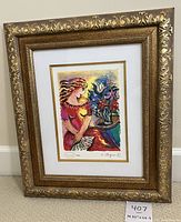 Full view of framed print with colorful woman and floral vase, gold decorative frame and white matting.