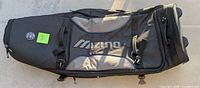 Overall view of black Mizuno golf bag carrier showing handle, zipper compartments, and logo patch.