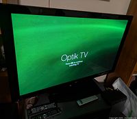 Pioneer Elite PRO-506PU plasma TV powered on showing Optik TV home screen with green background.