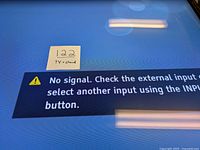 Close-up of TV screen showing 'No signal' message indicating no input detected but screen functionality shown
