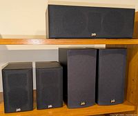 Front view showing 2 Alpha Mite bookshelf speakers, Alpha Center speaker, 2 Image 1B bookshelf speakers with fabric grilles and PSB logos.