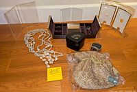 Full lot shot showing purse, necklace, jewellery box, picture frames, watch box