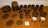 Wide view of all Hornsea Heirloom and Saffron pieces arranged on table, showing overall collection and quantity of dishes and cups.