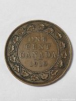 Front side of the 1919 Canadian one cent coin showing inscription and oak leaf wreath design.