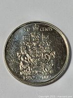 Front view of a 2002 Canadian 50 cent coin showing coat of arms and date range 1952-2002 with crown, lion, and unicorn design details.