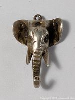 Elephant head pendant in sterling silver, front view showing shape, detailing, and loop attachment