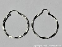 Pair of twisted design 925 sterling silver hoop earrings on a white background.