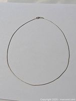 Full view of the 18 inch sterling silver snake chain necklace laid flat.