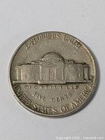 Reverse side of American Jefferson nickel coin showing Monticello building and inscriptions.