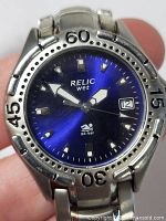Close-up photo of Relic wristwatch blue dial with silver indices, date window at 3 o'clock and water resistance marking.