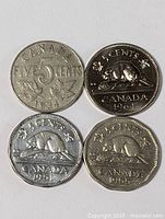 Four Canadian nickels arranged in a square showing obverse designs including date and denomination