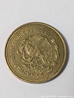 Photo showing one side of the vintage Mexican coin with the national emblem and inscription "ESTADOS UNIDOS MEXICANOS".
