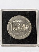Front view of the Canadian 100th anniversary Winnipeg dollar coin in protective capsule showing detailed engraving and dates 1874-1974.