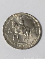 Top view of the coin showing Queen Elizabeth II riding a horse, surrounded by inscriptions and denomination.