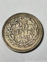 Reverse of silver 1940 25 cent coin showing denomination and date surrounded by laurel wreath.