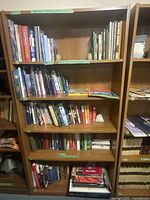 Full view of two wooden bookshelves filled with assorted books on multiple topics.