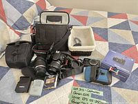 Overview of Canon EOS DSLR with lenses, charger, filter, strap, memory card, bags, and PowerShot box
