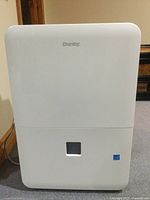 Front view of white Danby dehumidifier showing water tank window