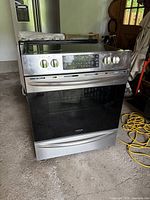 Front view showing overall stainless steel finish, knobs, oven door and glass cooktop